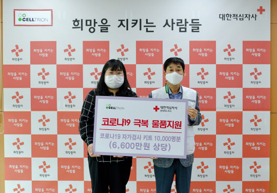 31일 양현주(왼쪽) 셀트리온 글로벌SCM본부장이 김경배 대한적십자사 충북지사 회장에게 코로나19 자가검사키트 디아트러스트 홈 테스트 1만개를 전달하고 기념촬영을 하고 있다. 셀트리온 제공